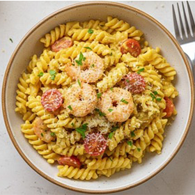 Macarrão fusilli com camarão, linguiça, tomates cereja, coberto de queijo ralado com ervas frescas.